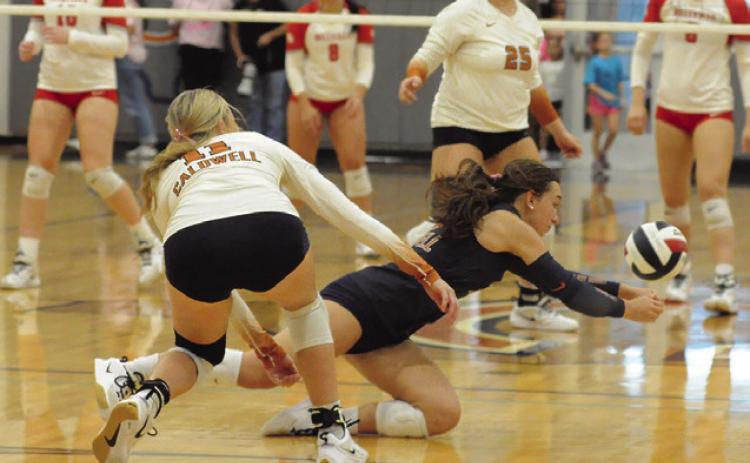 CALDWELL LIBERO NATALIE EASTEPP dives for the ball during the Caldwell-Bellville match on Friday. Also pictured are, Reese McManus and Kierstyn Macik. Tribune photo by Denise Squier