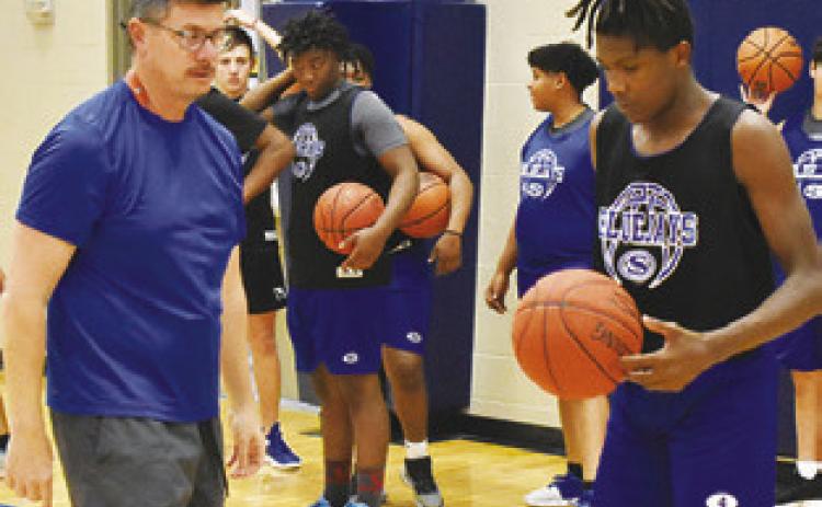 MARK MINATREA, Snook’s new head basketball coach, offers instruction at the Bluejays’ Monday practice session.