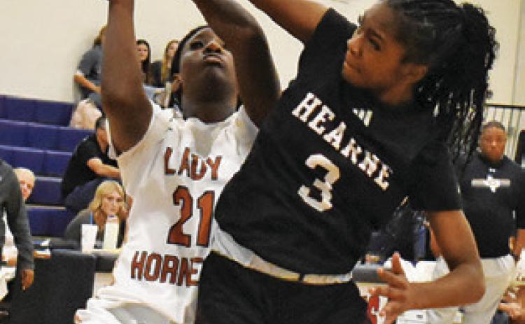 MESHA JOHNSON attempts a layup while a Hearne player defends during the annual Lady Hornet Classic last week. Tribune photo by Roy Sanders