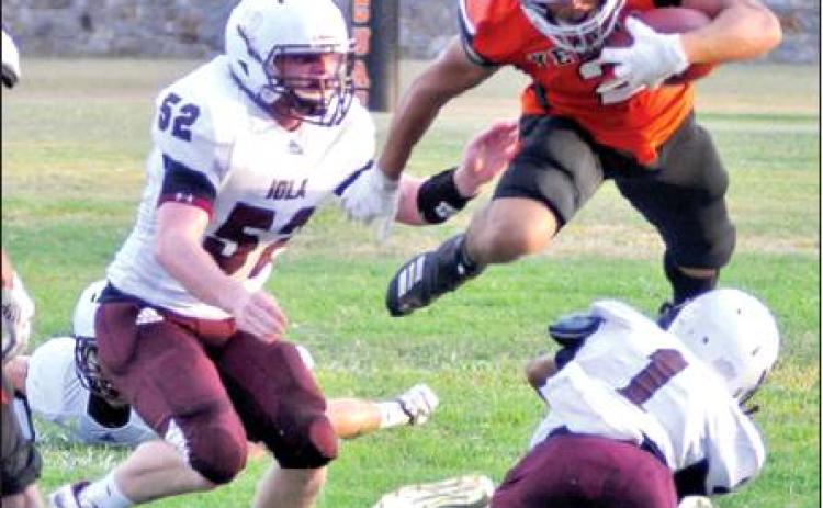 SOMERVILLE’S JEREMIAH TEAGUE leaps over these Iola defenders last Friday in the Yeguas 20-12 home loss. Somerville faces Texas Wind this week. -- Tribune photo by Roy Sanders