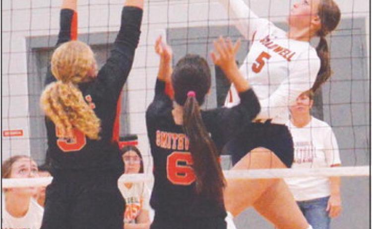 CALDWELL’S KYSEN TONEY hits the ball over two Smithville blockers during the Lady Hornet’s district win last Friday night.