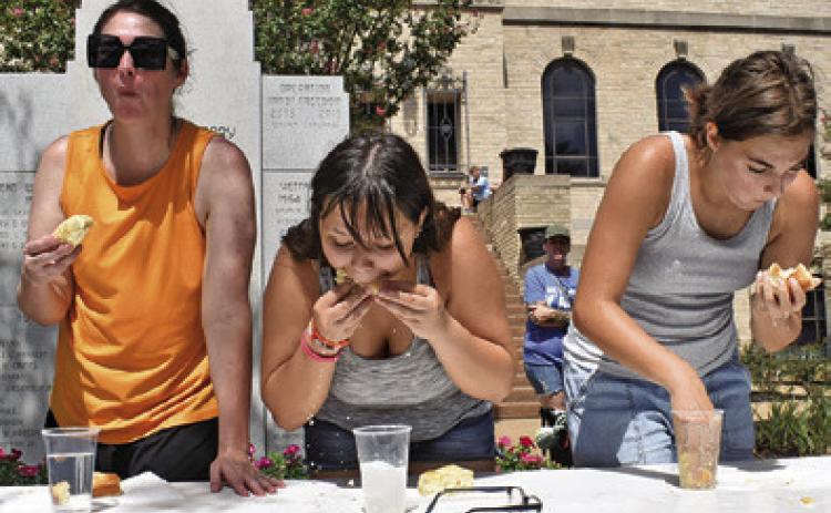 CONTESTANTS IN THE Women’s division eat as fast as they can.