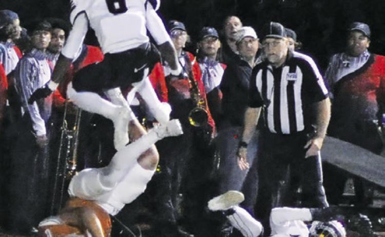 COY BECKA DIVES for yardage as these Madisonville players defend. Tribune photo by Denise Squier