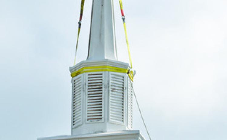 THE NEW STEEPLE is put in place at New Tabor Brethren Church last Wednesday. Tribune photo by Roy Sanders