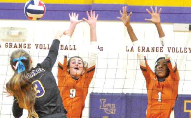 CALDWELL’S CORINNE DILLARD and Aaliyah Massingill reach to attempt to block a hit from La Grange’s Lanie Doyle during the Lady Hornets’ win over La Grange. -- Tribune photo by Roy Sanders