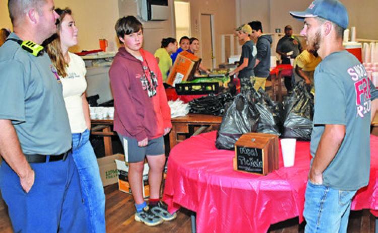 PLATES ARE PREPARED on Sunday, Aug. 23, for the Snook Volunteer Fire Department’s annual barbecue fundraiser.
