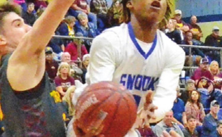 SIDNEY MACK OF Snook moves in for this shot despite some heavy pressure from the Thorndale defense. Mack was Snook’s leading scorer in the bi-district game. -- Tribune photo by Roy Sanders