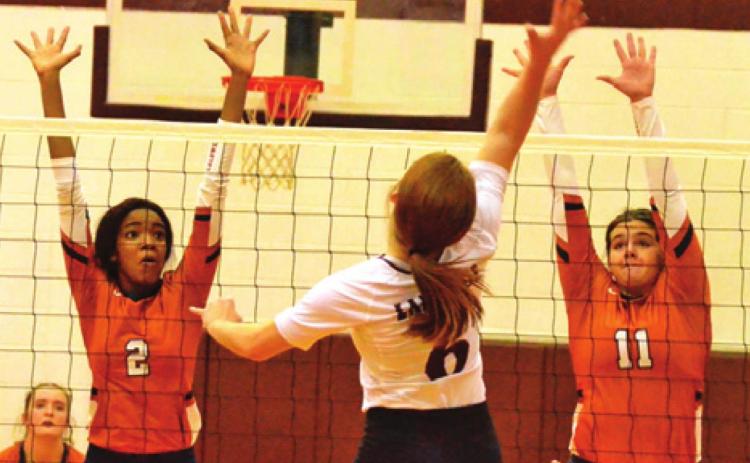 CALDWELL’S AALIYAH MASSINGILL and Addison Reed reach to attempt to block a hit by Cameron Yoe’s Haley Tucker during the Lady Hornets’ win on Friday. -- Tribune photo by Roy Sanders