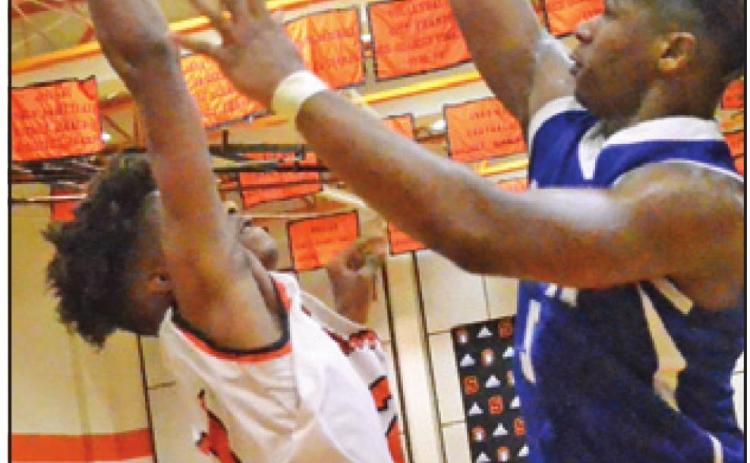 SNOOK’S QWAN YOUNG makes the go-ahead points to make it 48-47 as Dominic Tucker of Somerville defends. The teams battled into overtime with Snook winning 50-49. -- Tribune photo by Roy Sanders