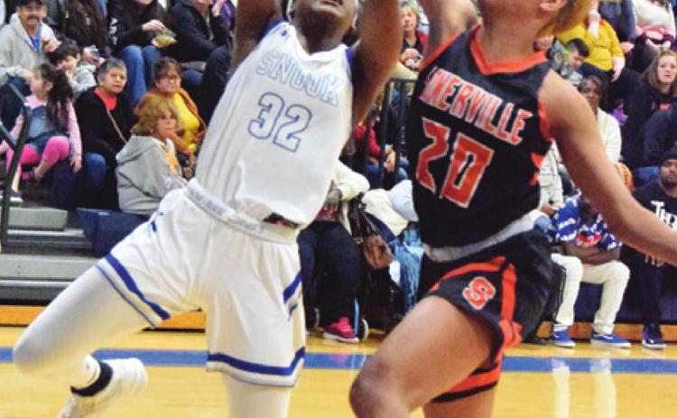 SOMERVILLE’S XADRIA MARTIN blocks a shot by Snook’s Jaivan Stringfellow during the Snook-Somerville district game last Tuesday night in Snook. -- Tribune photo by Denise Hornaday