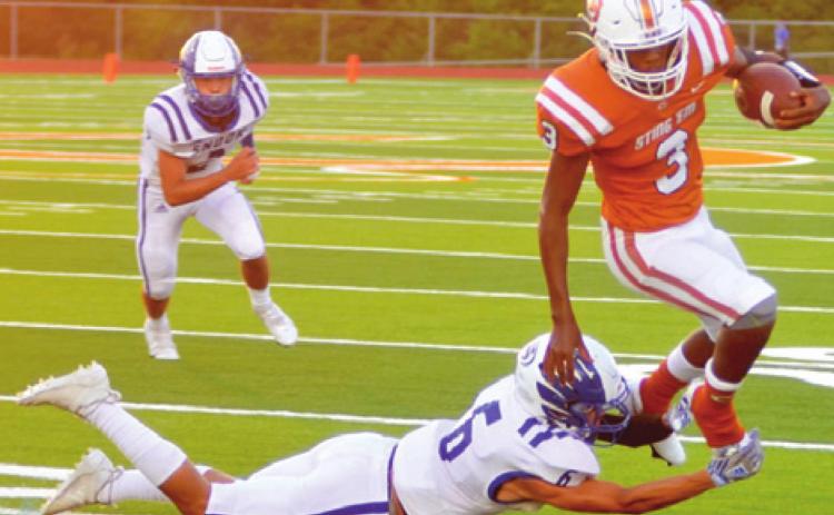 DONTAVIAN JOHNSON CARRIES the ball for Caldwell as Snook’s Jose Garcia defends. Caldwell held on last Friday at Hornet Stadium for a close victory 28-26. -- Tribune photo by Roy Sanders