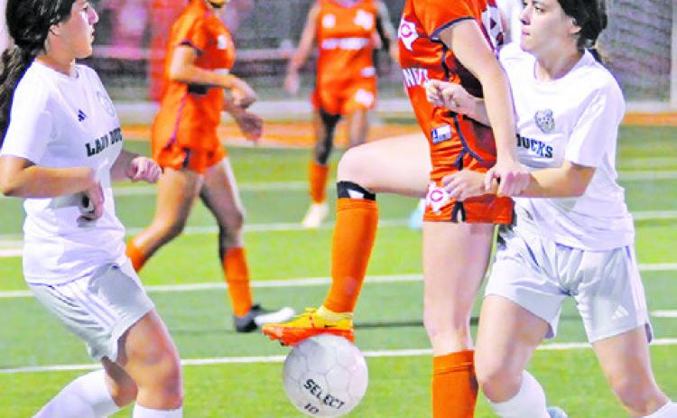 CALDWELL SENIOR AND TEAM captain Cadie Coston is challenged by two Taylor players during the Lady Hornets’ final district game this season at Hornet Field. -- Tribune photo by Denise Squier