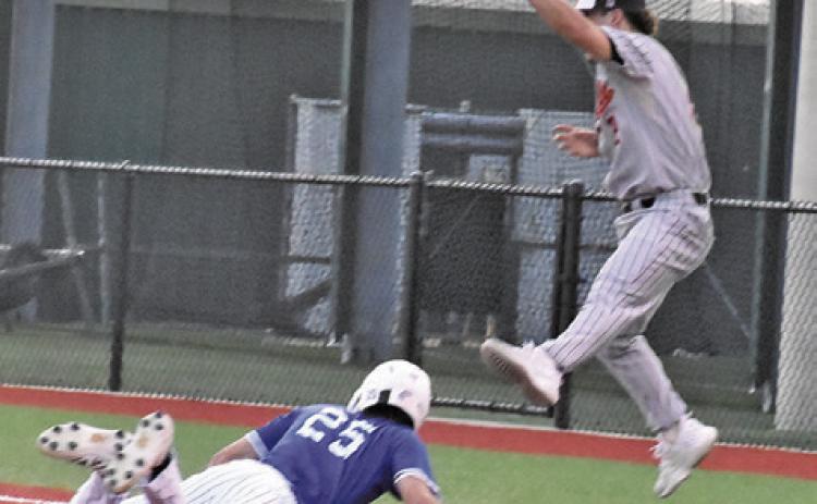 SOMERVILLE FIRST BASEMAN Colt Holton leaps high to catch the ball as this Mumford base runner gets back to first base. Tribune photo by Roy Sanders
