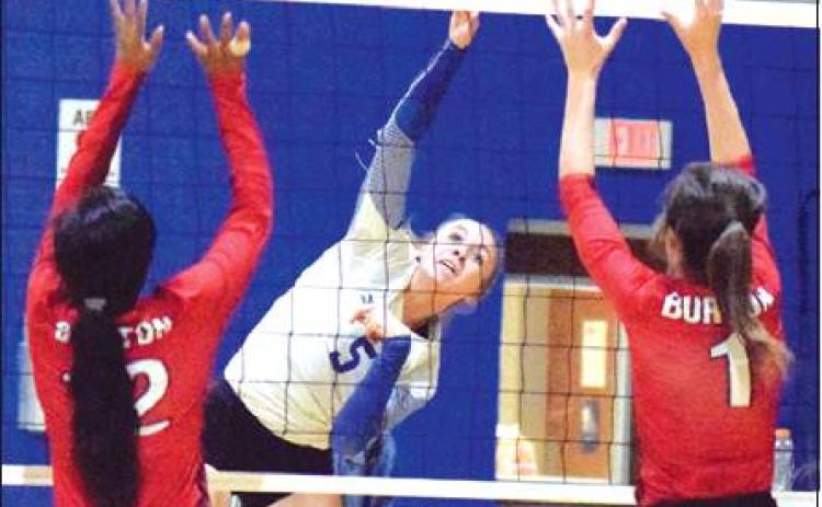 SNOOK’S KENZIE KMIEC hits the ball between Burton’s Azhane Graves and Alex Countouriotis during the Lady Jays’ win over Burton on Tuesday, Oct. 1. -- Tribune photo by Denise Hornaday