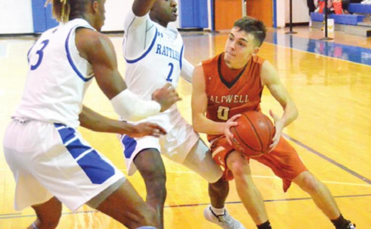 CALDWELL’S BOBBY LEROUAX dribbles the ball around these Navasota defenders last Friday in Navasota. The Hornets lost 53-41 and were to face Giddings on Tuesday in Caldwell.