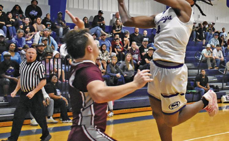 JOHN CARR LUNGES for this shot against Iola in Snook’s win. Tribune photo by Roy Sanders
