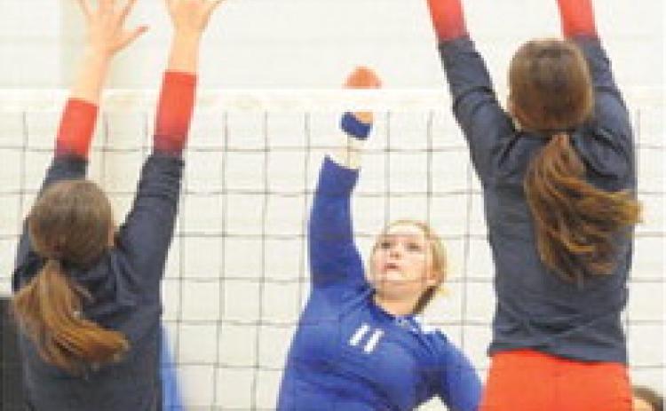 SNOOK’S AUBREY BECKER HITS the ball between two Madisonville blockers during the Navasota Varsity Volleyball Tournament last Thursday and Saturday. -- Tribune photo by Denise Squier