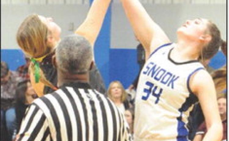 ALEXIS MACIK REACHES to hit the ball to a teammate during the opening tip-off of the Snook-Iola game. -- Tribune photo by Denise Squier