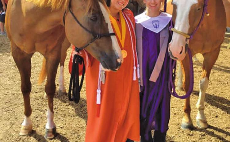 CALDWELL’S SABINE LAZO and College Station’s Reagan Jennings wore their caps and gowns during a recent horse show to share their graduation with their “barn family” who won’t be able to attend their upcoming graduation ceremonies due to COVID-19 crowd restrictions.