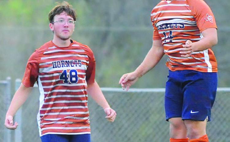 CALDWELL’S NAM LE HEADS the ball during the Hornets’ final game of the season against Taylor. Reese Simpson looks on. For more about the game, see story inside. -- Tribune photo by Denise Squier