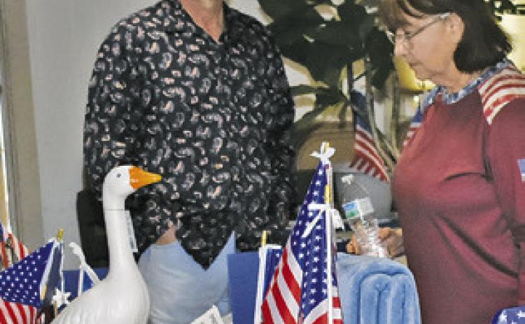 AUCTION ITEMS are displayed and viewed on Saturday at the July 4 celebration at the Hermann Sons Life Hall in Deanville.