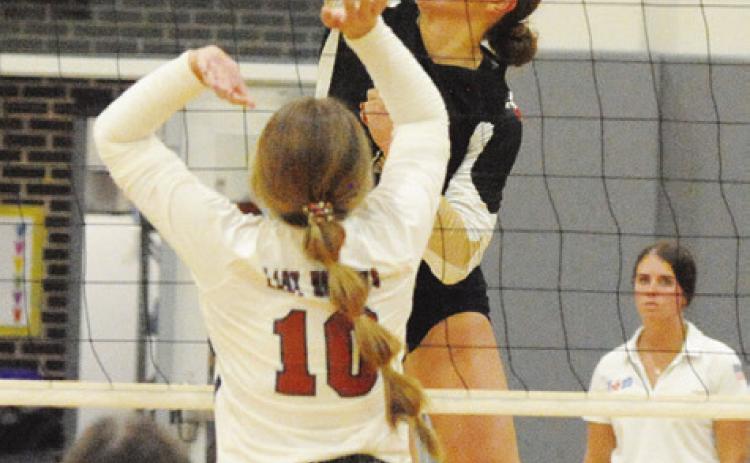 GIDDINGS’ FAITH ZOCH gets a kill against the Lady Hornets while Caldwell’s Kelly Urbanovsky attempts a block during the Lady Buffs’ straightset district victory at Hornet Gym in Caldwell on Friday. Also pictured is Brooklyn Snider. -- Tribune photo by Denise Squier