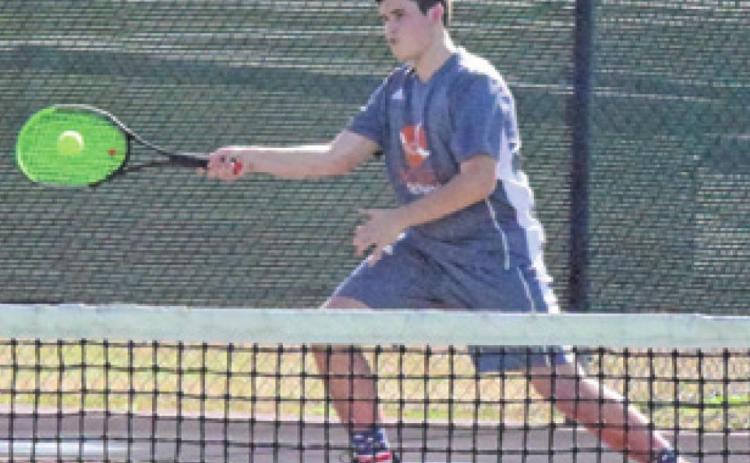 CONNOR HUGHSON returns serve during his first round boys doubles match at the Bastrop Winter Cup Varsity Tennis Tournament last Friday. -- Tribune photo by Denise Squier