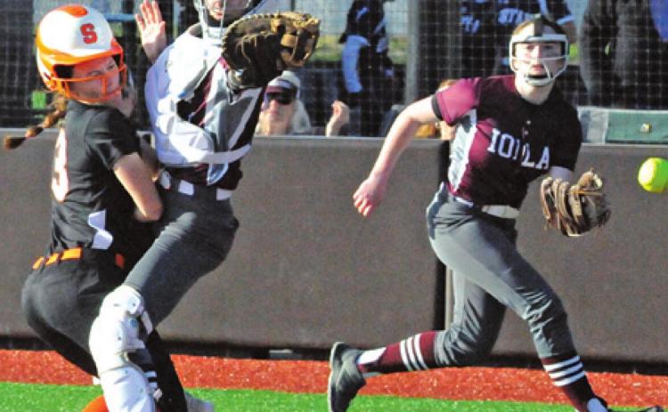 EMMA KOVASOVIC slams into the Iola catcher to score during the Lady Yeguas’ 23-17 win last week. -- Tribune photo by Denise Squier