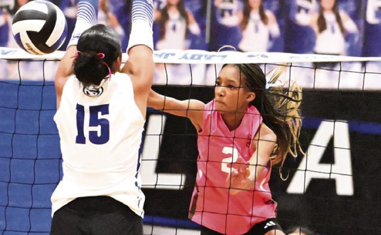 SOMERVILLE KARYS ELLIS GETS the ball past the attempted block from Snook’s Teyana Nickerson for a kill during the Snook-Somerville rival match last Friday at the Snook High School Gym. Tribune photo by Denise Squier
