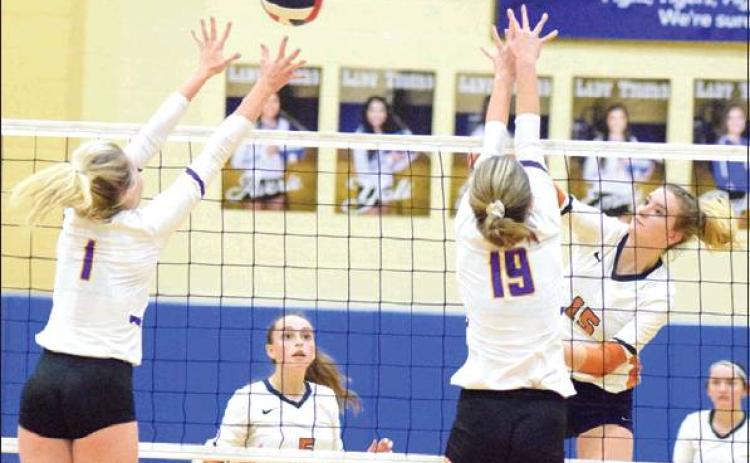 CALDWELL’S ELIZABETH SEE HITS the ball over Liberty Hill’s Ashley Nelson and Ailie Hair during Friday night’s area match in Rockdale. See led the Lady Hornets in kills with 19 and scored the final point in the fifth set to win the match. -- Tribune photo by Denise Hornaday
