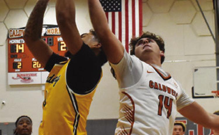 JOHN FRYREAR of Caldwell reaches high for this rebound against Academy Tribune photo by Roy Sanders