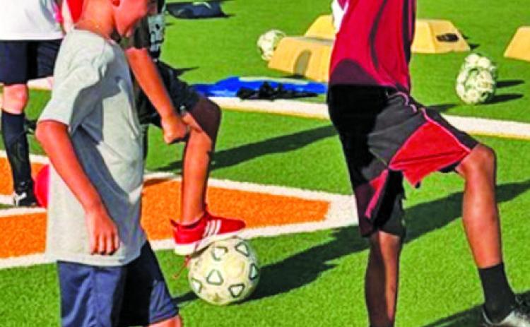 ATHLETES ATTENDING Hornet Soccer Camp work on their footwork skills.