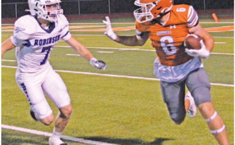 JAMIN WHITE CARRIES the ball after a reception against Robinson.