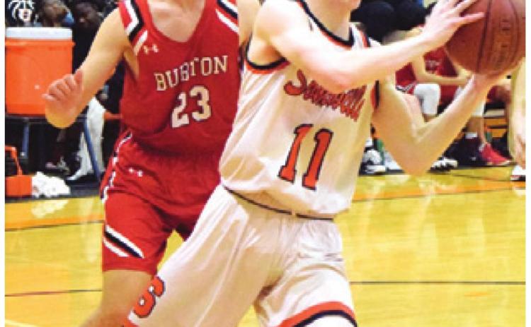 GARRISON BALLARD gets around a Burton defender at the baseline to pass the ball to a teammate during Friday night’s home game.