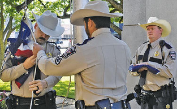 BURLESON COUNTY Sheriff’s Sgt. Chase Welch, and Deputies Steven Guerrero and Jonathan Weichert raise the flags.