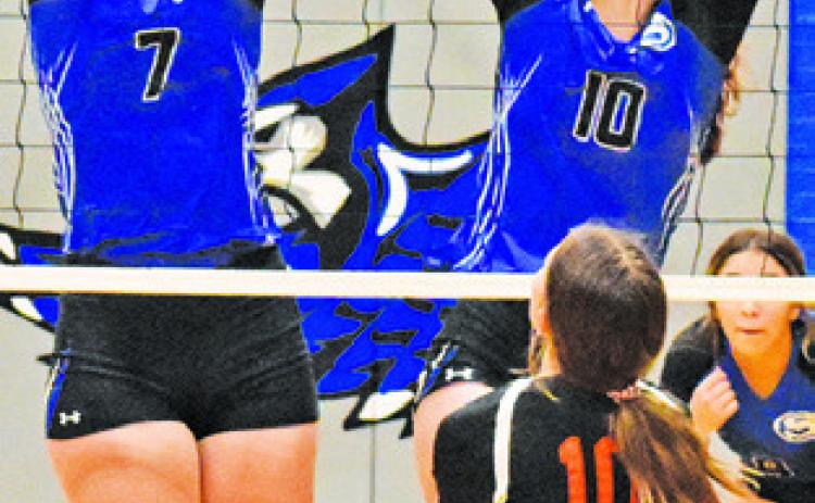 ALEXIS MACIK and Payton Sodolak reach to block a hit during Friday’s Lady Jay win over Buckholts 25-20, 25-19, 25-9.