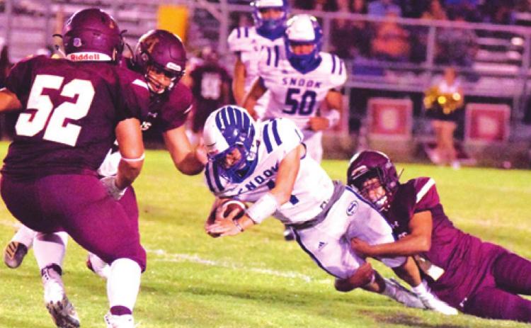 SNOOK QUARTERBACK GARRETT LERO fights for yardage during Friday night’s 22-7 win over Milano. Lero ran for 94 yards and threw for 131 yards in the win. The Bluejays are hosting Iola this Friday night at 7 p.m. at Bluejay Stadium. -- Tribune photo by Denise Hornaday