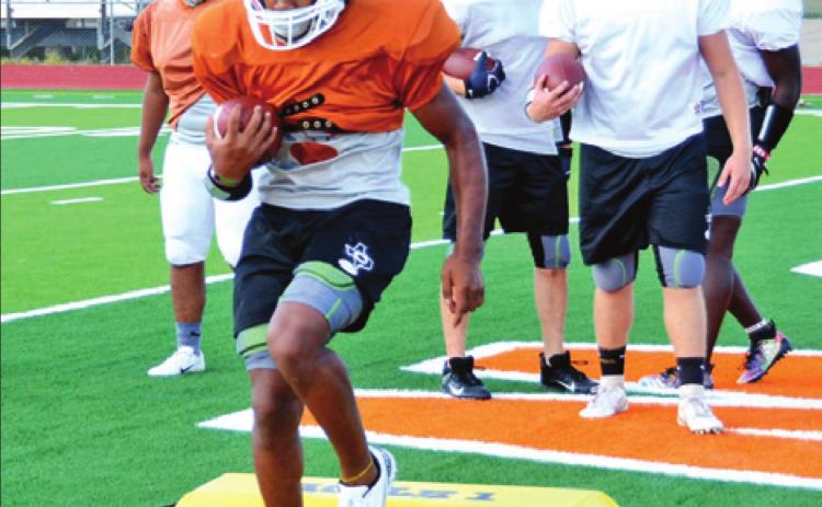 CALDWELL’S CADARIUS WILLIAMS carries the ball on this drill on Monday during the Hornets’ workout. -- Tribune photo by Roy Sanders