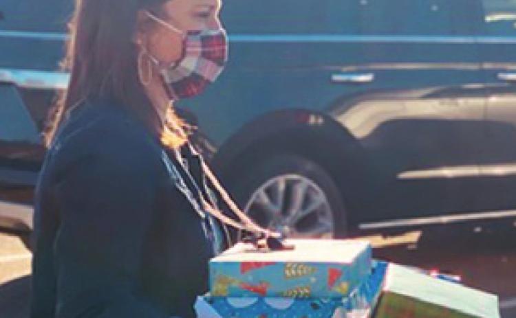 NICKI DRGAC, Caldwell Intermediate School counselor, loads gifts into a vehicle to be delivered to area families. Over 400 gifts were given to 90 Caldwell ISD children and their families through Hornets Helping Hornets.
