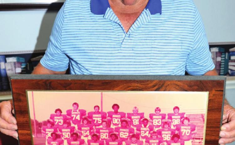 VANCE McMANUS HOLDS this plaque honoring the 1980 Caldwell Hornets district champions. -- Tribune photo by Roy Sanders